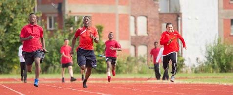 Boys running on a track towards the camera