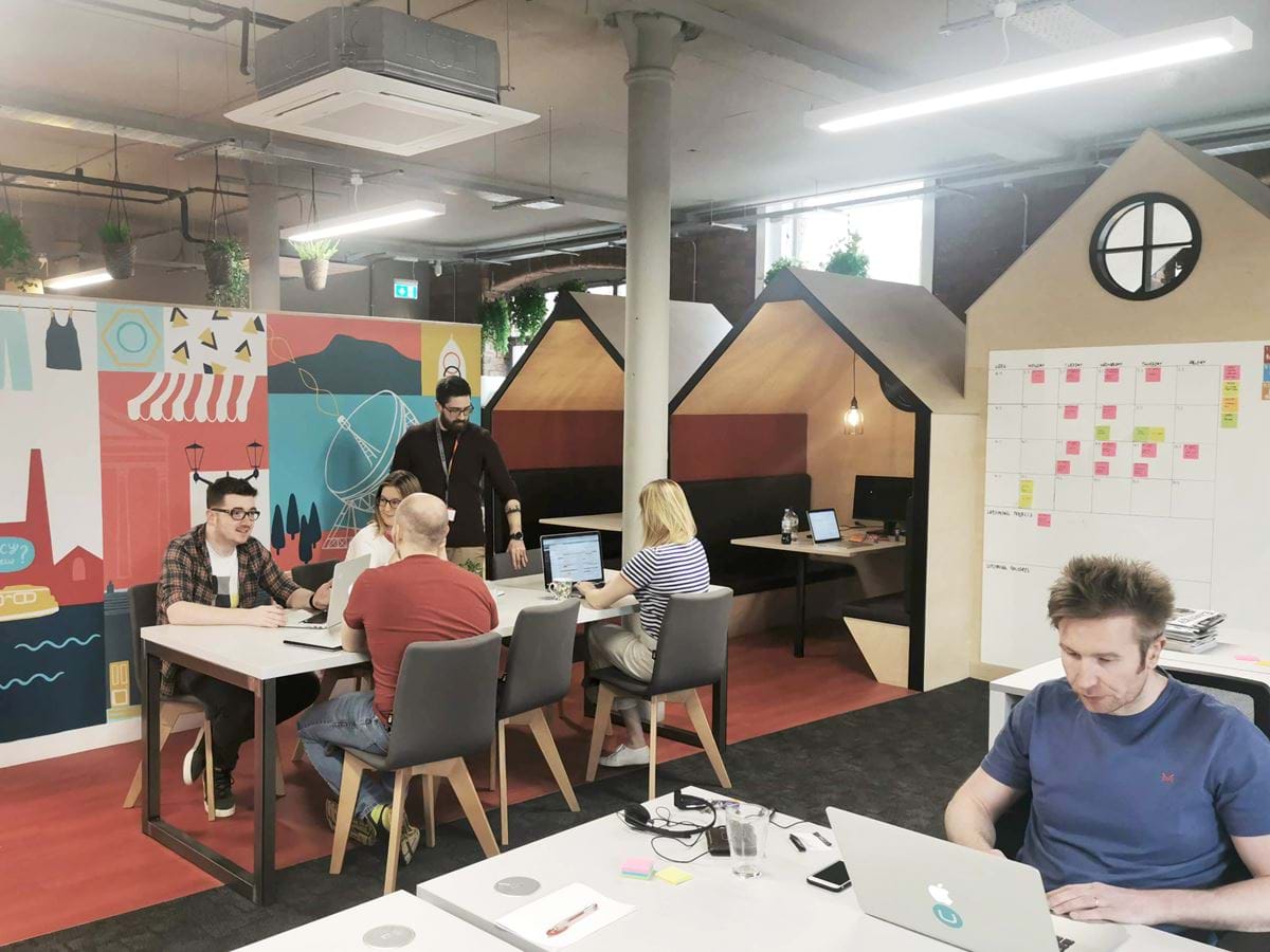 People sat around tables in the Macclesfield office