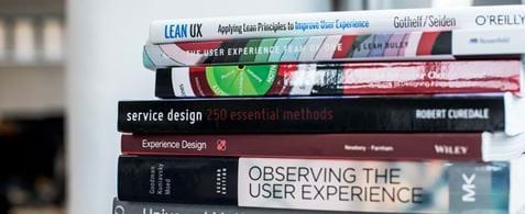 A stack of colourful user experience and service design books.