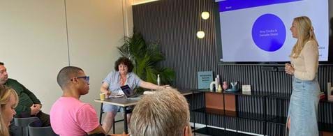 Nexer's Amy Czuba delivers a presentation to a crowded meeting room at the RTC meetup